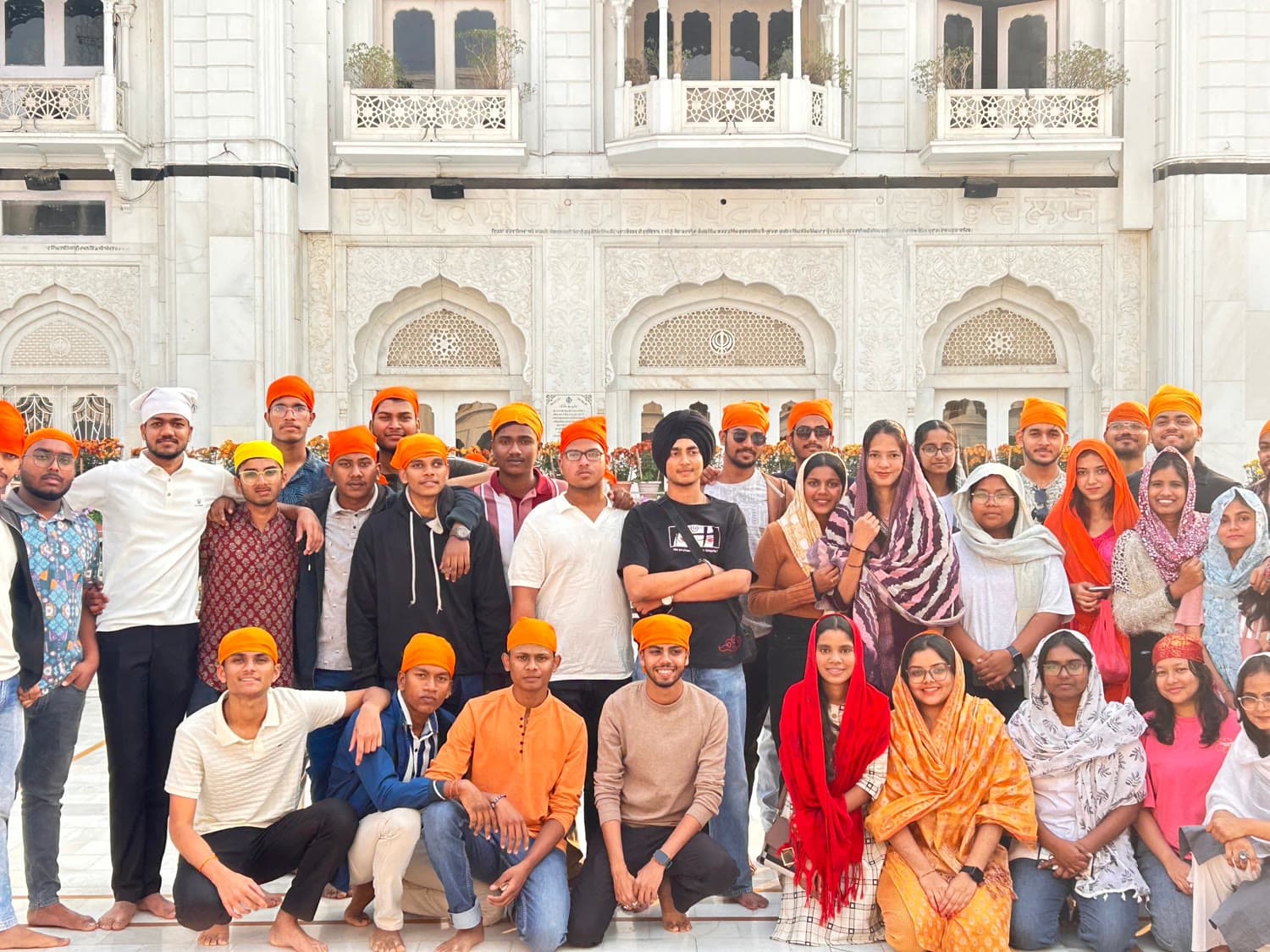 The whole group on the marble courtyard of a gurudwara, heads covered