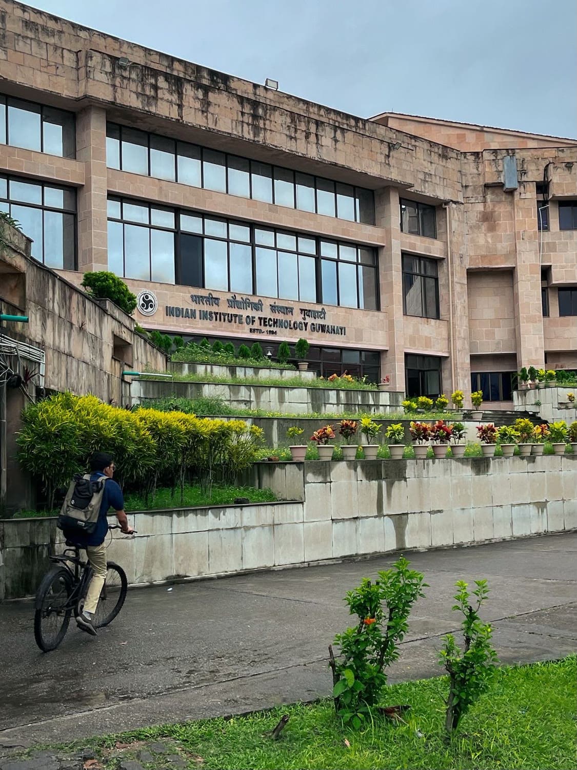 The main building at IIT Guwahati, a cyclist passing in front