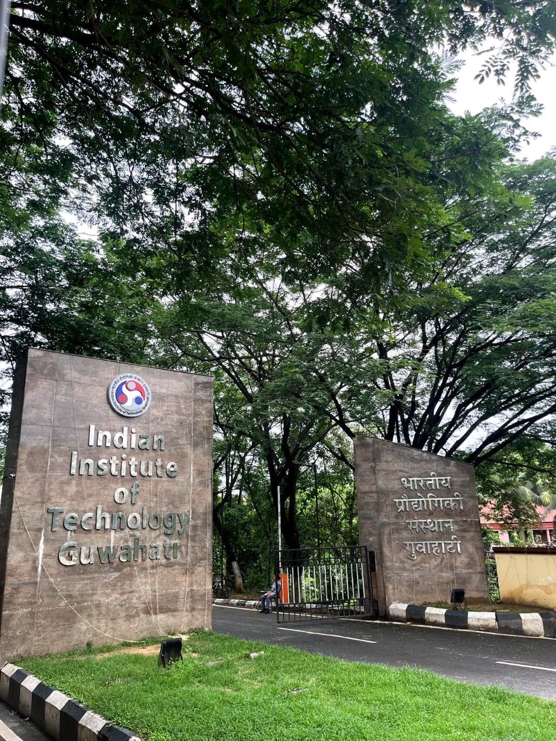 The stone entrance gate of IIT Guwahati under heavy trees
