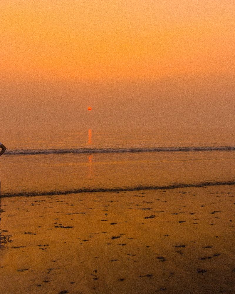 Two people on Juhu beach at sunset