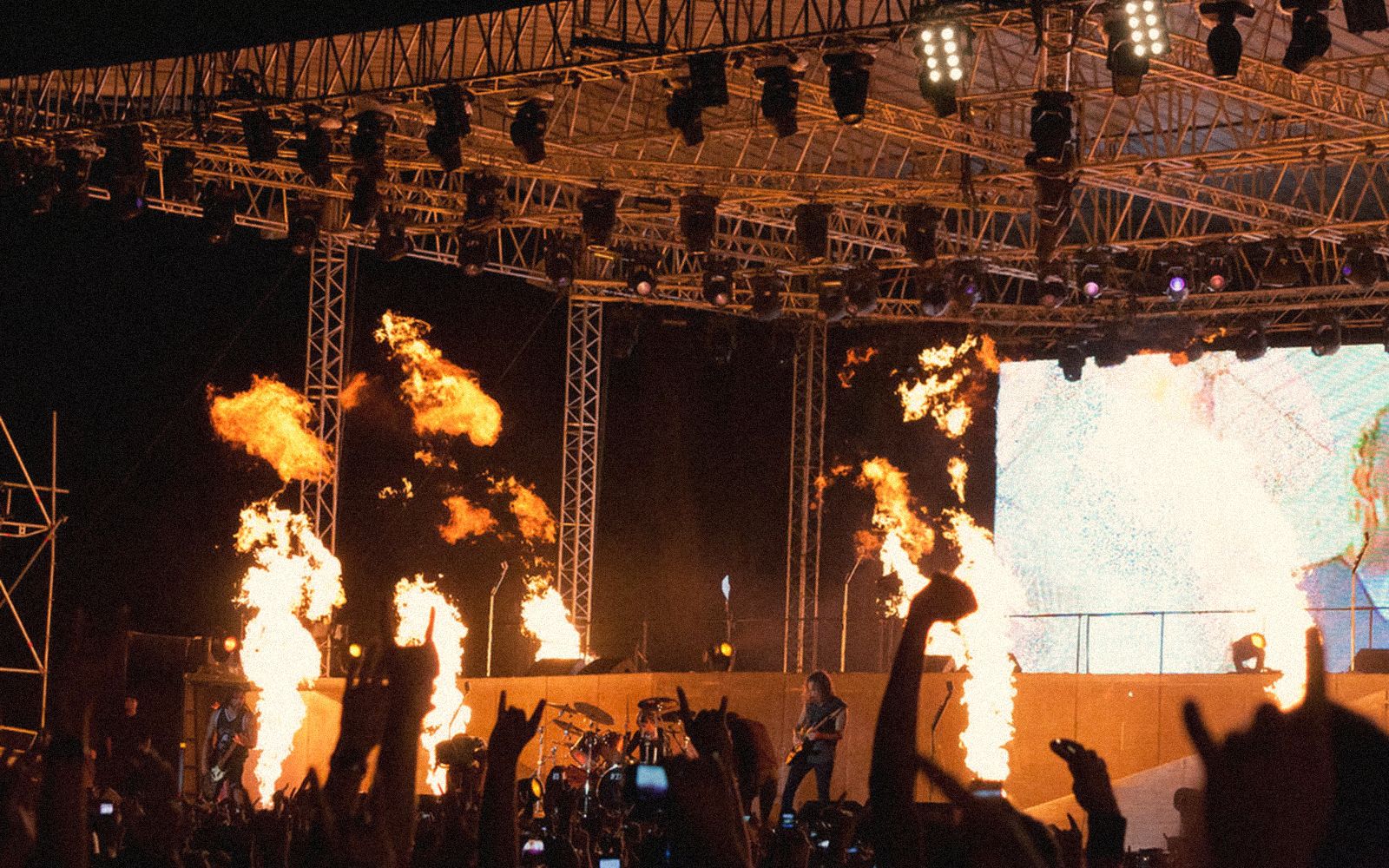 A festival stage throwing fire into the night