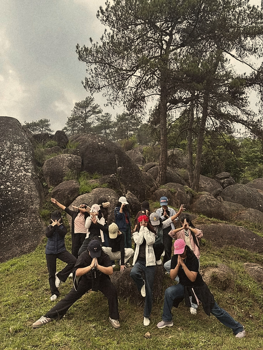 A crew striking a pose on a hillside, faces hidden