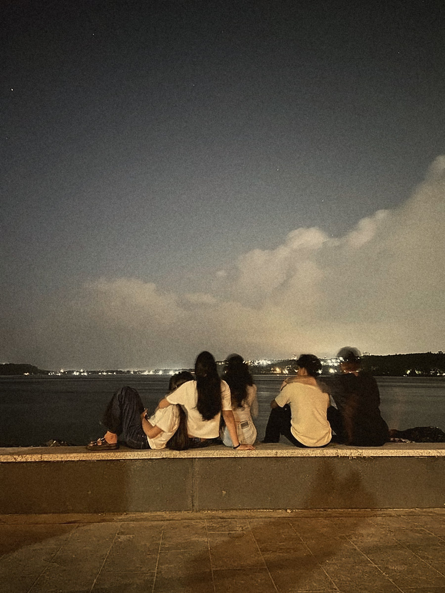 Two friends on a sea wall at dusk