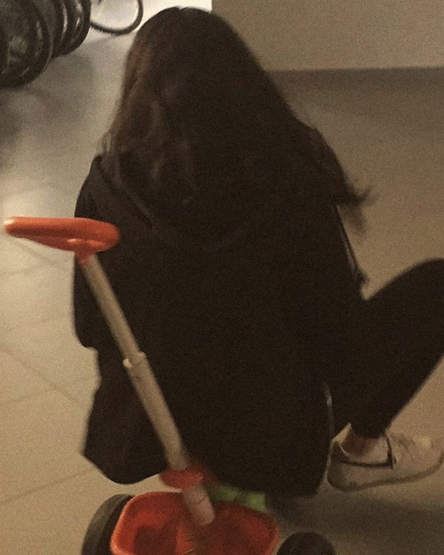 A friend riding a kid’s tricycle late at night