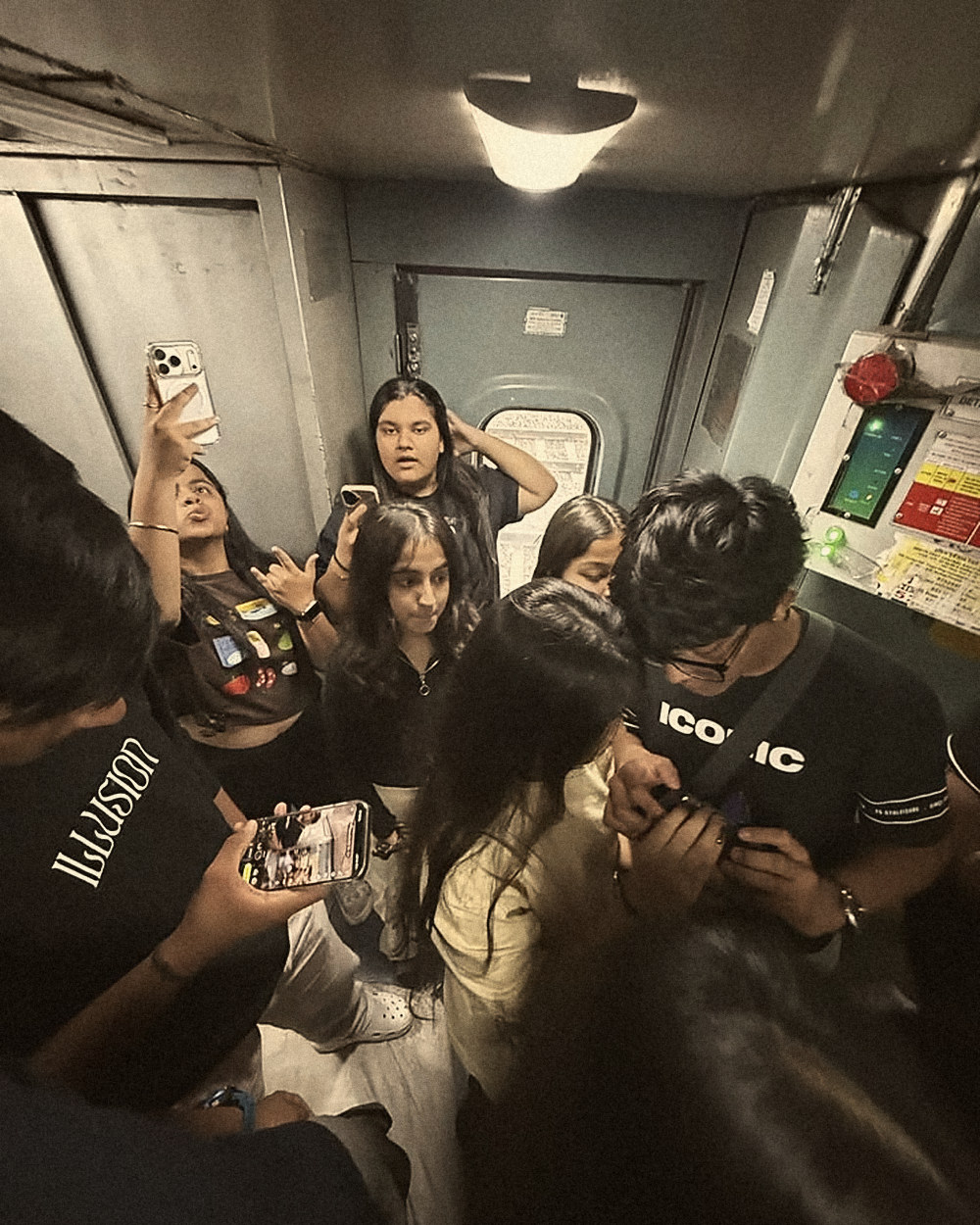 Friends crowded by the train door, phones out